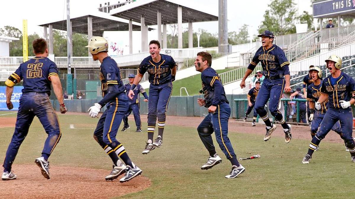 St. Thomas Aquinas' Chris Ruckdeschel (25) jumps up at home plate after an infield home run in the eighth inning and is greeted by teammates as they play George Jenkins Eagles in the Class 8A Semifinals of the FHSSA Baseball State Championships in Fort Myers, Florida, June 1, 2018.