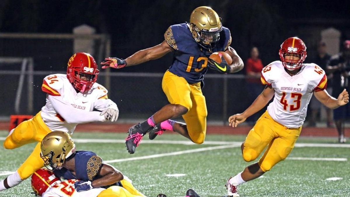 Saint Thomas Aquinas HS Asante Samuel leaps as he runs the ball tin the first quarter as they play Deerfield Beach HS at Saint Thomas Aquinas HS, Oct. 6, 2017.