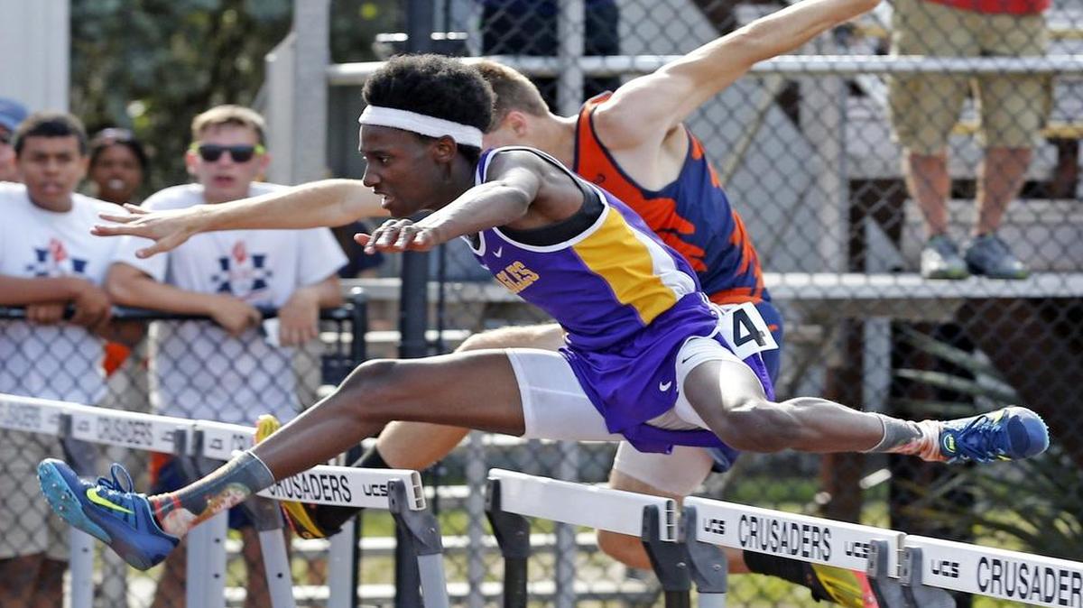Torry Holmes of Northwest Christian Academy tackles a hurdle en route to a victory in the 100-meter hurdles at the Region 4-1A track and field meet at Dade Christian School.