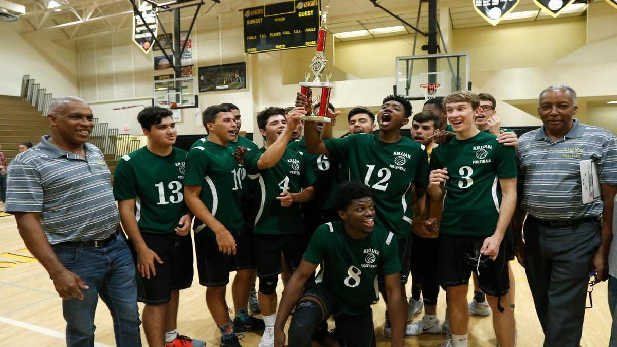 Killian coach Clinton Reid, right, and assistant Earl Reid, left, celebrate with the team after winning the GMAC title.