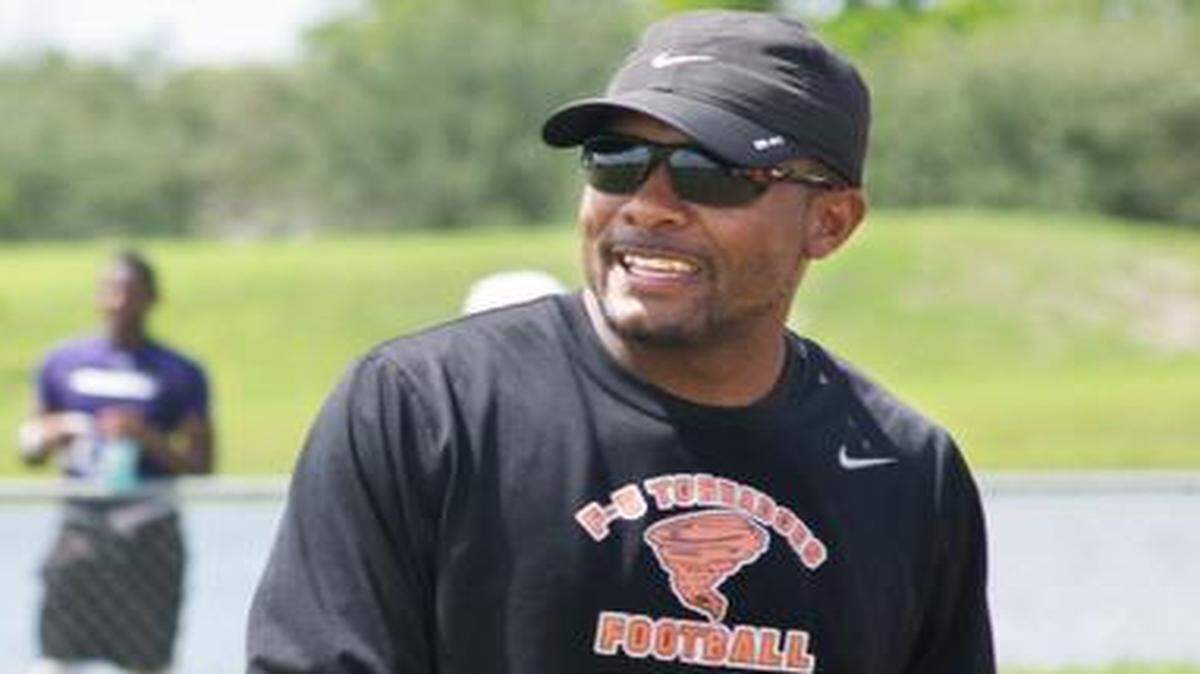 Booker T. Washington coach Tim Harris Jr. watches his team play at the Dolphins' 7 on 7 tournament in Plantation, Fla., on Saturday, June 14, 2014.