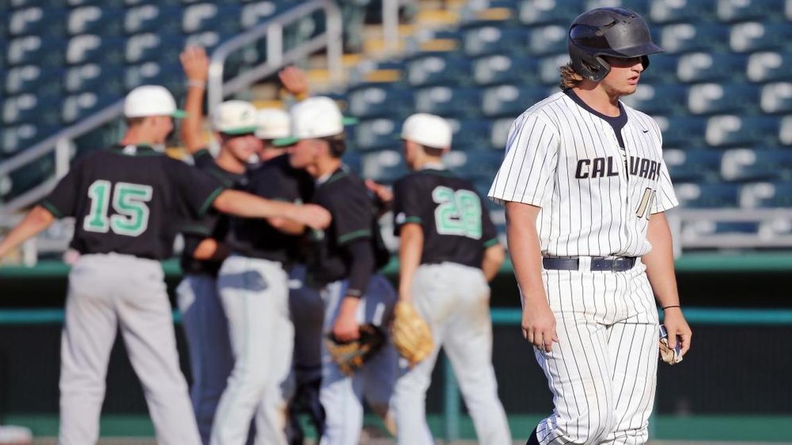 Calvary Christian's right fielder Cameron Stadler (18) walks off the field after being tagged at first base as Pensacola Catholic players celebrate the win in Class 4A state semifinal at Centurylink Sports Complex - Hammond Stadium in Fort Myers on Fri., May 26, 2017.