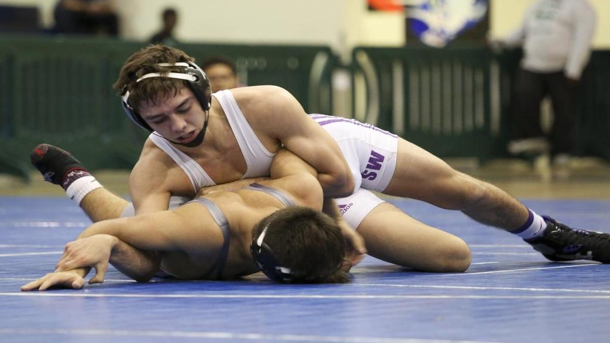 Southwest Miami's Franco Valdes, top, holds Anthony Vizcaino from Coral Gables during the GMAC Wrestling Championships at Ronald W. Reagan / Doral High School on Feb. 6, 2016. Valdes won the match.