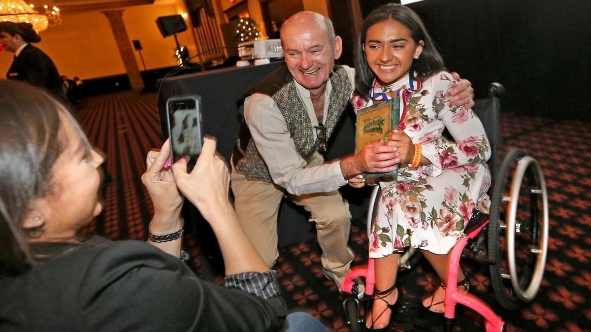 Leo Suarez/Walter Krietsch Courage Award co-winner Cypress Bay's Isabella Matos gets a hug from her coach Joseph Monks as her mother Kathy Matos gets their picture at the Miami Herald Broward Athletic Awards banquet at the Signature Grand in Davie on Thurs., May 25, 2017.