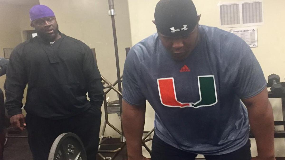 New Miami High football coach Sedrick Irvin, left, coaches 6-5, 330-pound sophomore offensive lineman Dontae Lucas through his weight training drills inside the school’s weight room on Monday, April 24, 2017.