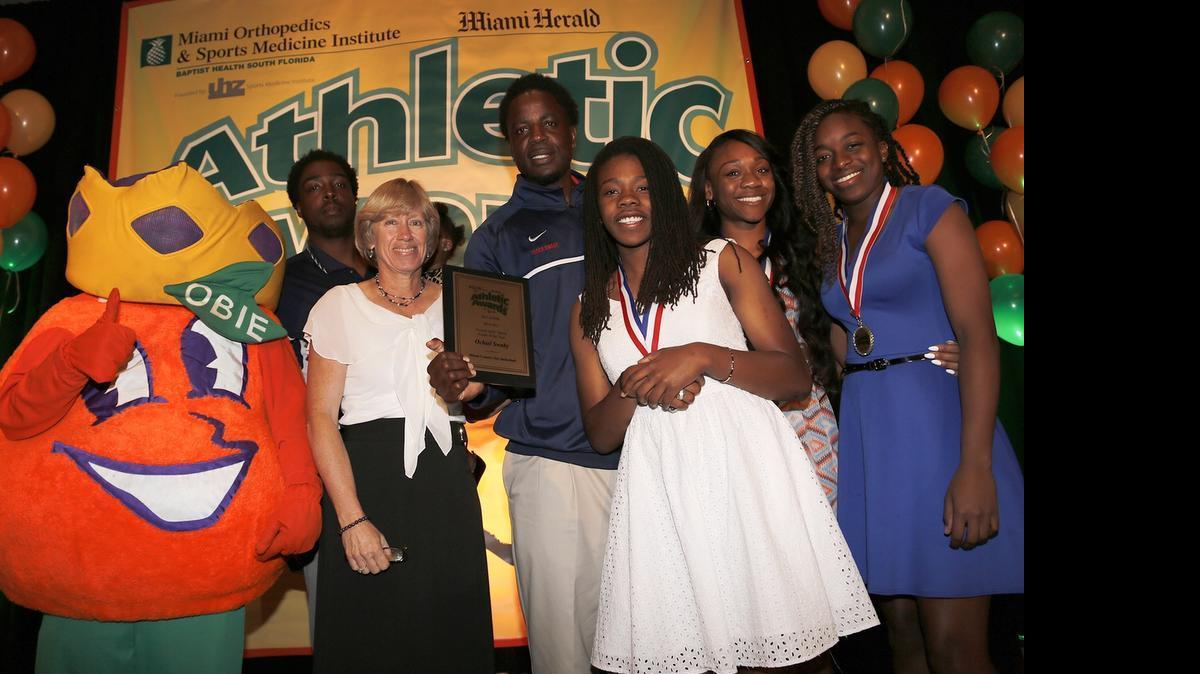 
Miami Country Day girls’ basketball coach Ochiel Swaby holds his plaque for Coach of the Year for Female Sports during the All-Dade Athletic Awards at Jungle Island on Wednesday, May 20, 2015. At left is Miami Herald columnist Linda Robertson, and at right are three of Swaby’s players: Kelsey Marshall, Ogechi Anyagaligbo and Channise Lewis.
