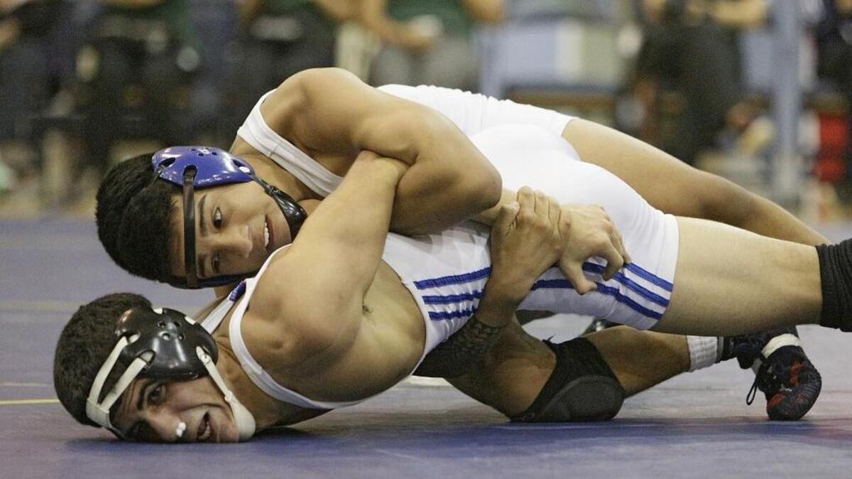 South Dade’s Ozzy Lugo (top), shown wrestling Matias Caceres of Braddock last season, is vying for a third straight state title.