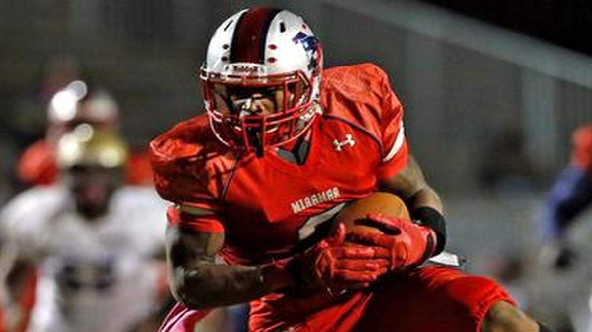 
Miramar receiver Khalil Lewis scores a touchdown in the second quarter after breaking loose from Cypress Bay’s Danny Montoya at Miramar High School, Oct. 24, 2014.
