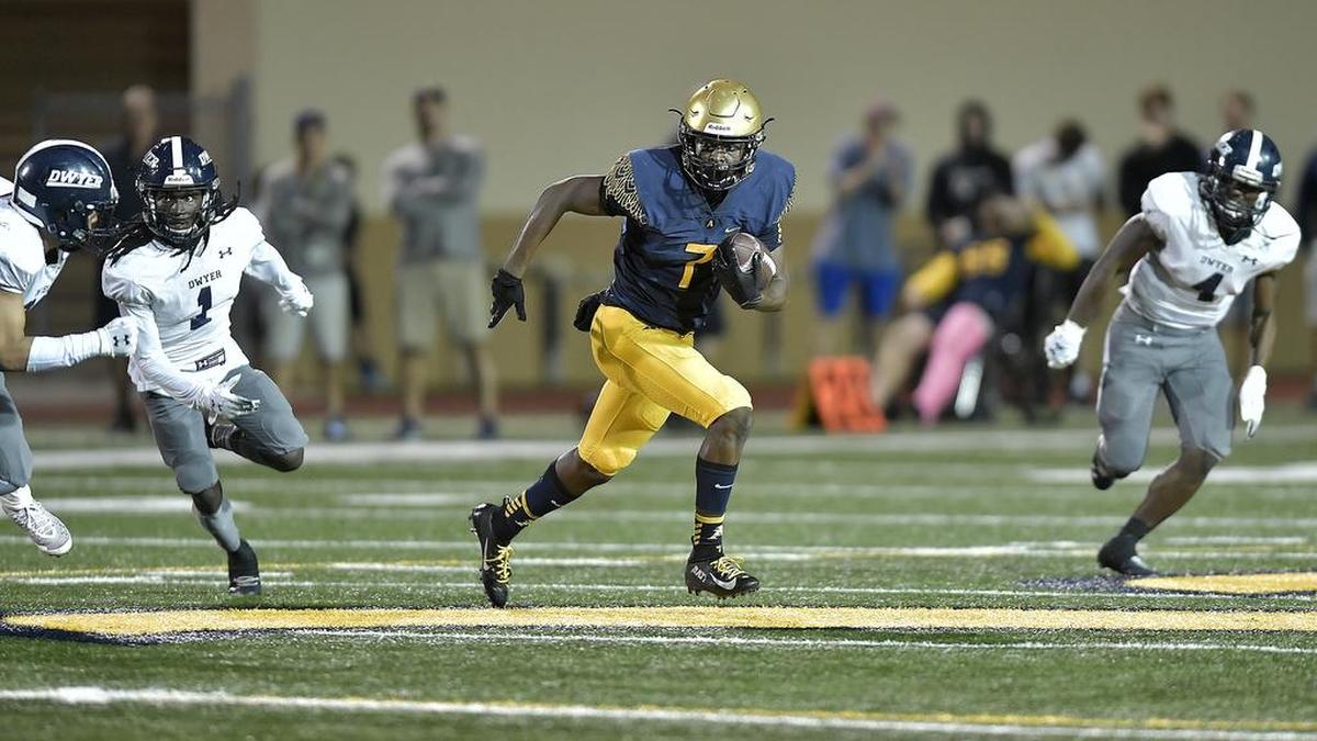 St. Thomas Aquinasâ Jordan Battle runs past the Dwyer defense during the first half of their 7A regional final game, Friday, November 23, 2018. St. Thomas Aquinas won 35-0.