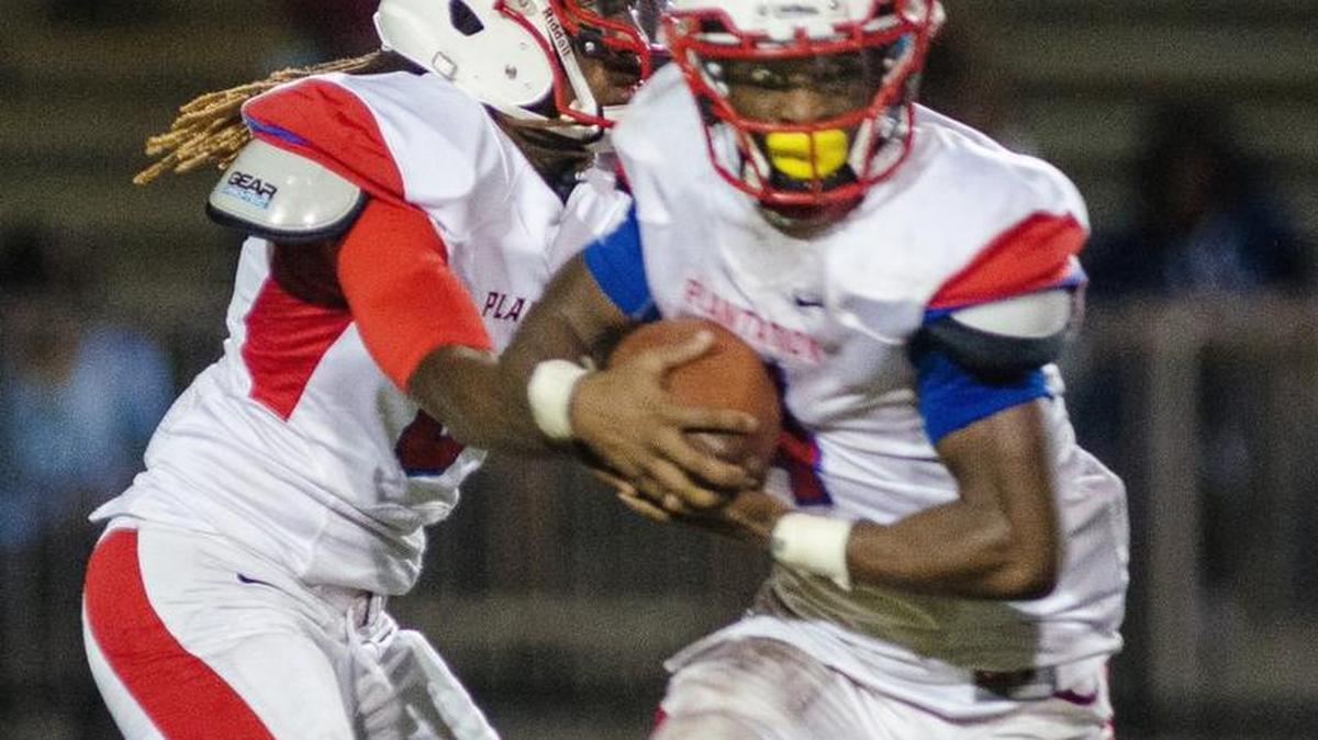 
Plantation quarterback Roshard Branch hands the ball to Maurice Lawrence in the first half of their game against Miramar on Friday night.
