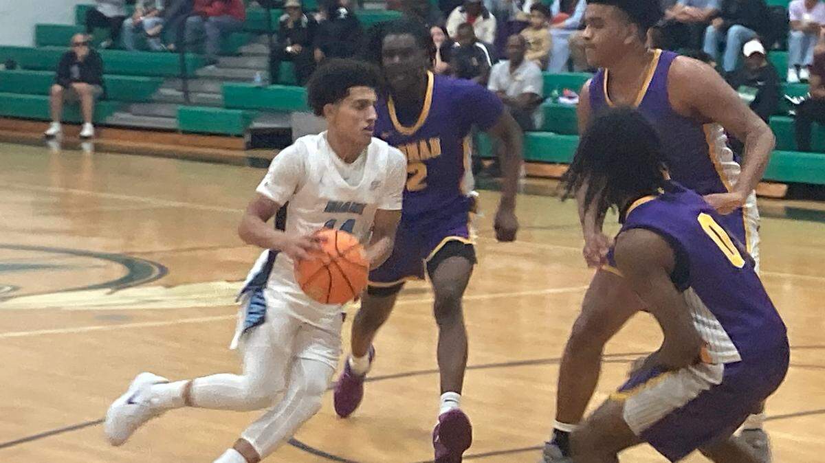 Miami Palmetto point guard Santiago Henriquez takes on Roman Catholic defenders and drives toward the basket. He finished with 24 points.
