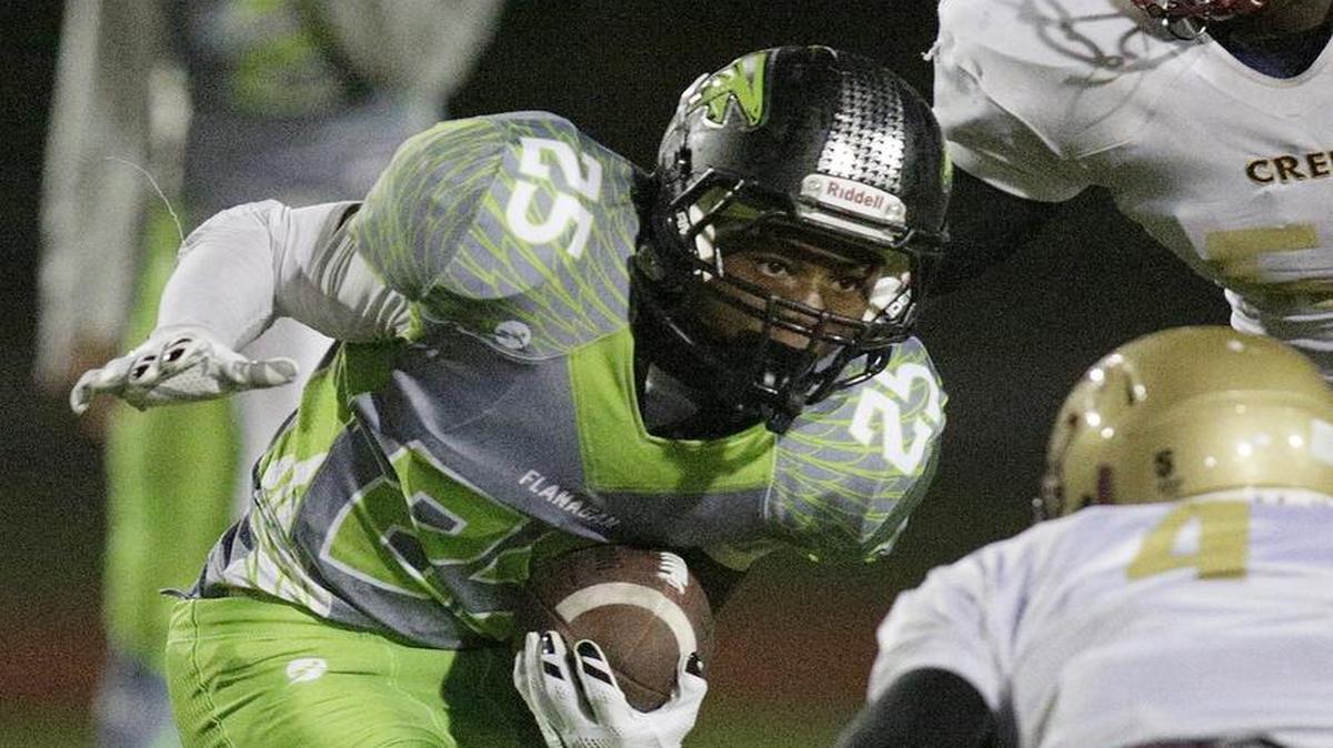 
Flanagan’s Darius Alexander (25) tries to escape Coconut Creek defender during their football game on Friday, September 4, 2015 at Flanagan High School in Pembroke Pines.

