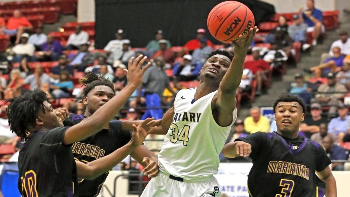 Calvary Christian Victor Uyaelunmo, 34, reaches for a ball under the basket as they play Marianna HS in the FHSSC 5A Boys semifinals in Lakeland, Florida, March 1, 2017.