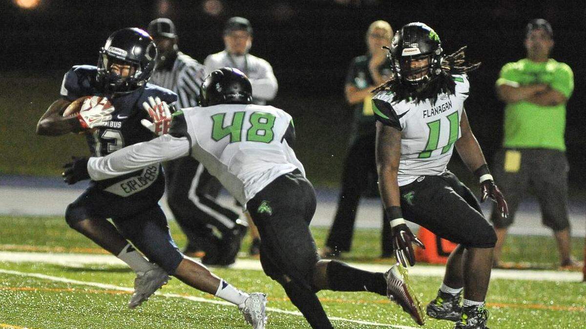 Darren Davis Jr. of Columbus attemps to avoid a tackle by Flanagan's Kevin McAllister during a Class 8A state semifinal game at Tropical Park in Miami on Friday, Dec. 4, 2015.
