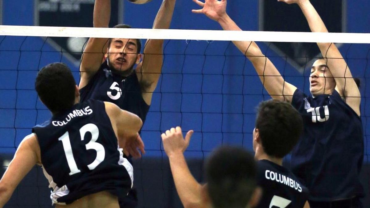 Columbus HS Danny Carrion 13, hits the ball into Alonso Mourning Sr HS Will Zuluaga 5, and Jayson Yao 10, in the GMAC boys' volleyball championship at Alonzo and Tracy Mourning High School, Tues., April 19, 2016.
