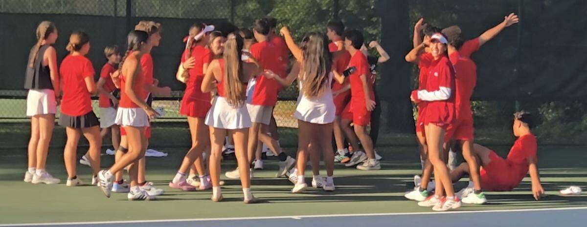 Members of the Doral Academy tennis program mob freshman Nico Escalante, who came off the bench to clinch the state title for the Doral Academy boys’ tennis team.