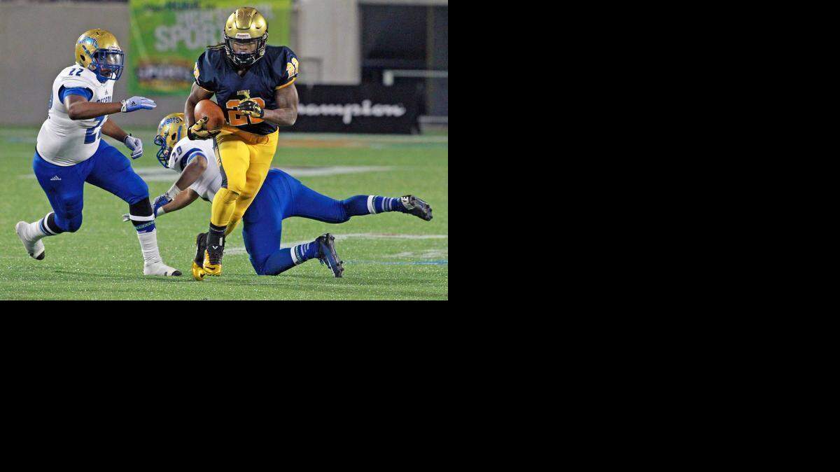 St. Thomas Aquinas running back Jordan Scarlett breaks a tackle and runs for a first-quarter touchdown as they play Osceola in the Class 7A football championship at the Citrus Bowl in Orlando on Dec. 12, 2014.

