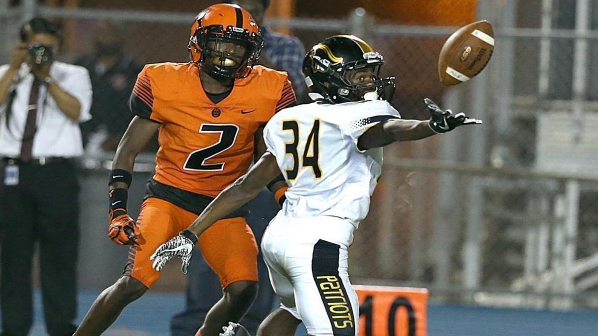 Heritage's (DB) Clarence Burley intercepts a pass against Booker T. Washington's (WR) Zahir Turner in the second quarter as the Booker T. Washington takes on American Heritage in a clash of nationally-ranked teams at Traz Powell Stadium in North Miami on Fri., Aug. 18, 2017.