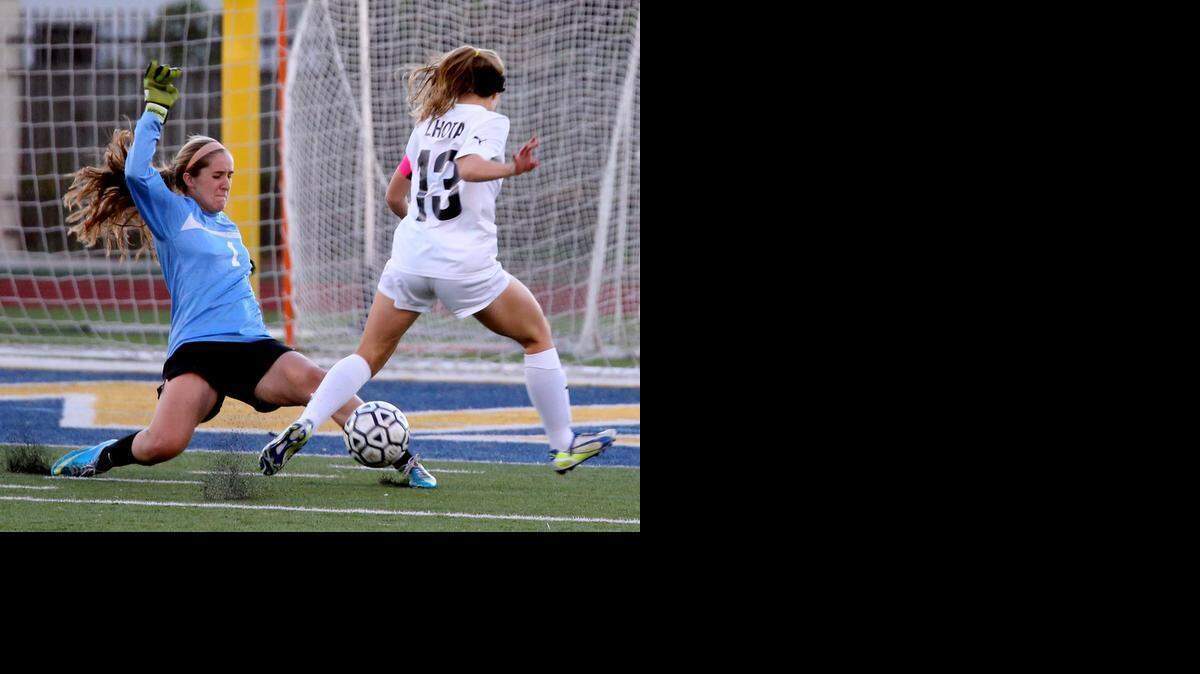 
St. Thomas Aquinas’ Connor Lhota’s kick is blocked by Cypress Bay goalie Melissa Aristizabal at St. Thomas Aquinas High School in a regional soccer roundup, January 27, 2014.

