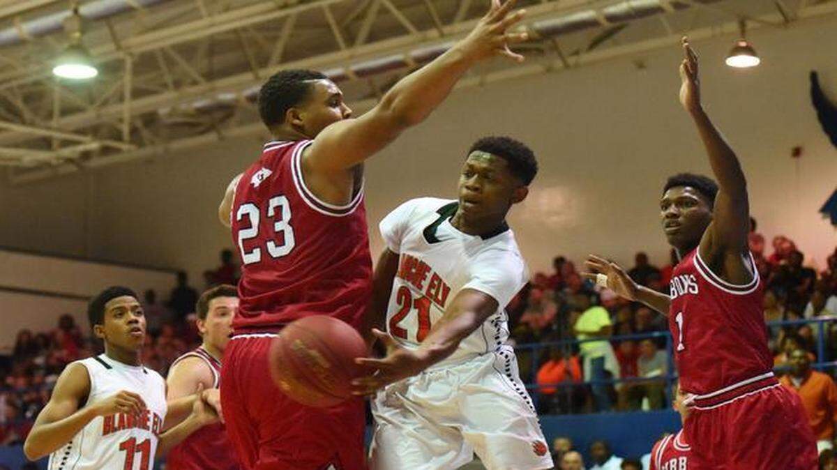 
Blanche Ely’s Javon Heastie, center, passes the ball as Cardinal Gibbons’ Richard McIntosh defends on the play during the BCAA Big 8 Boys’ Championship in Fort Lauderdale on Jan. 31, 2015.
