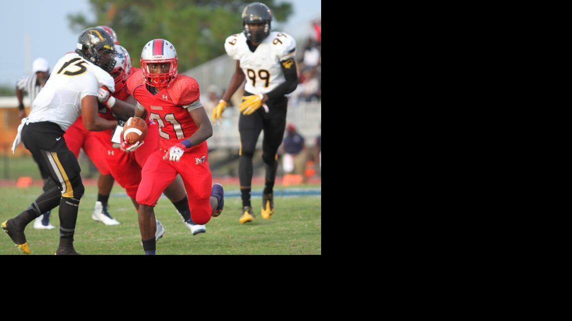 Gregori McRae (#21), junior Running Back for Miramar High, breezes past American Heritage football players during the game held September 6, 2014.


