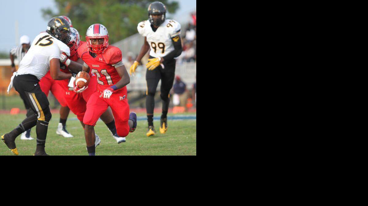 Gregori McRae (#21), junior Running Back for Miramar High, breezes past American Heritage football players during the game held September 6, 2014.

