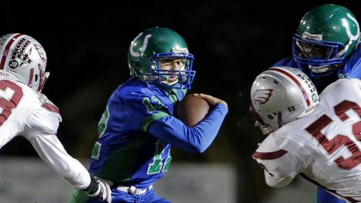 
Coral Springs' Jake Bofshever (12) runs past Douglas' Daniel Creseitelli (33) in Coral Springs on Friday, Oct. 31, 2014.
