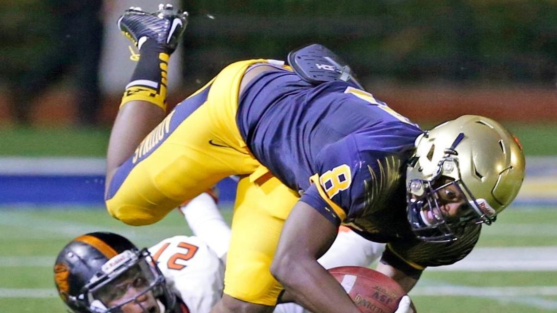 St. Thomas Aquinas wide receiver Michael Irvin II stretches for extra yardage against Booker T. Washington on Friday, Aug. 28, 2015.