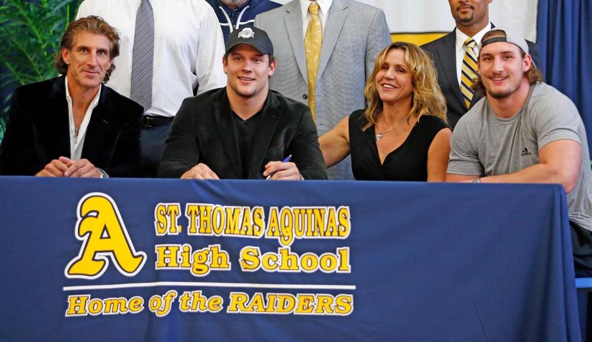 Nick Bosa, second from left, officially signs with Ohio State as his father, John, left, mother Cherly and brother Joey, who also attended Ohio State, look on during National Signing Day on Wednesday, Feb. 3, 2016 at St. Thomas Aquinas High in Fort Lauderdale.