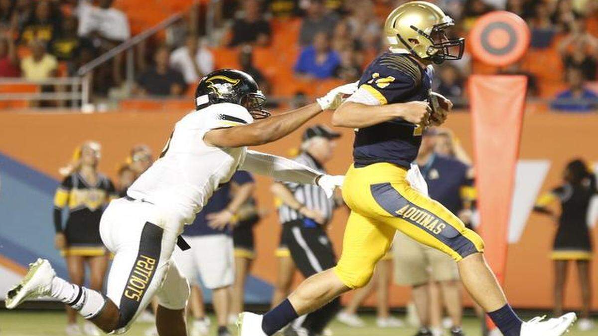 
St. Thomas quarterback Jake Rizzo scores against American Heritage at Sun Life Stadium on Friday, Aug. 29, 2014.
