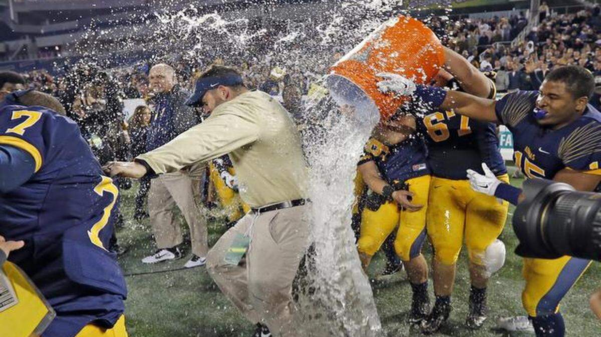 
St Thomas Aquinas’ Samuel Clausman (67) and Brandon Boyce (15) help dump Gatorade on Aquinas coach Rocco Casullo after they defeated Osceola in the Class 7A Boys Football Championship at the Citrus Bowl in Orlando, Florida, Dec. 12, 2014.
