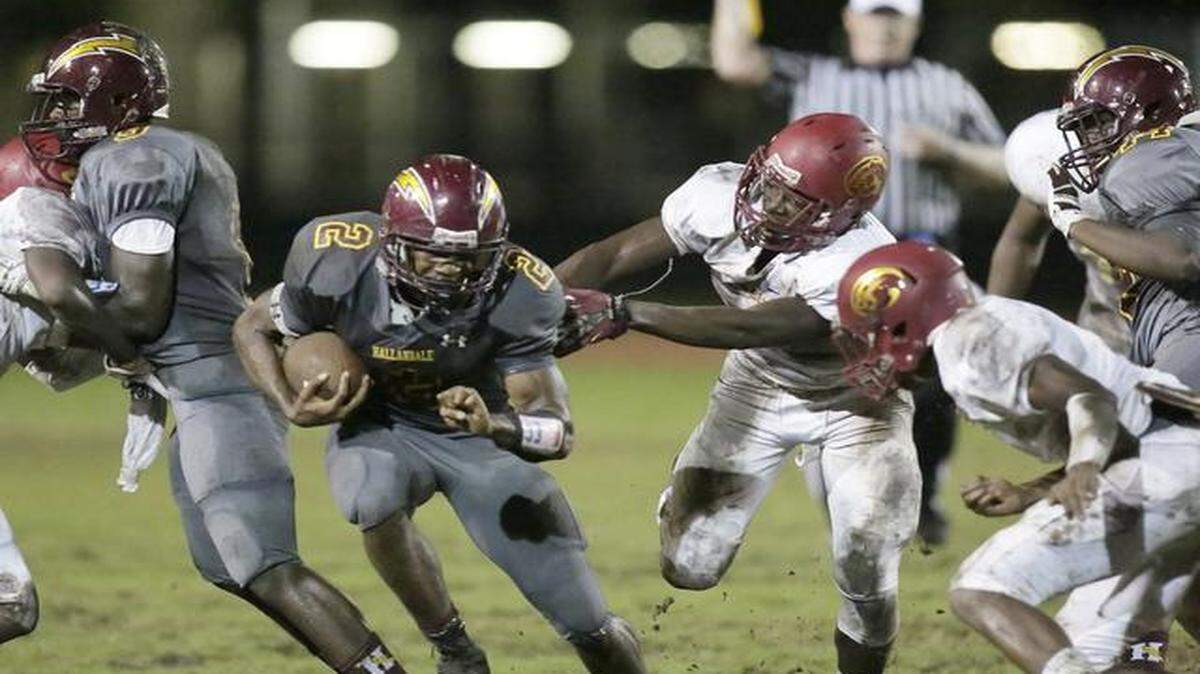 
Hallandale Chargers running back Taj McGowan (2) tries to escape Coconut Creek Cougars defenders during their football game on Friday, Sept. 26, 2014, at Hallandale High School in Hallandale.
