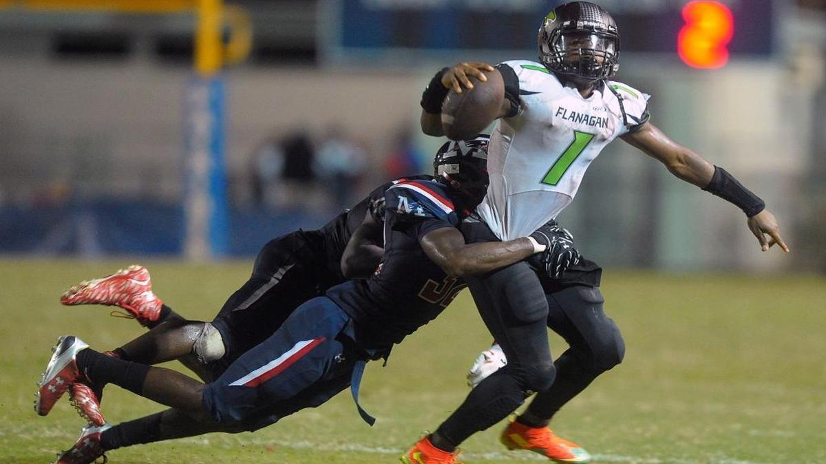 
Flanagan’s Cato Nelson drags Miramar’s Tavares Ladler for a few yards before being tackled Friday, Oct. 2, 2015 at Miramar High.
