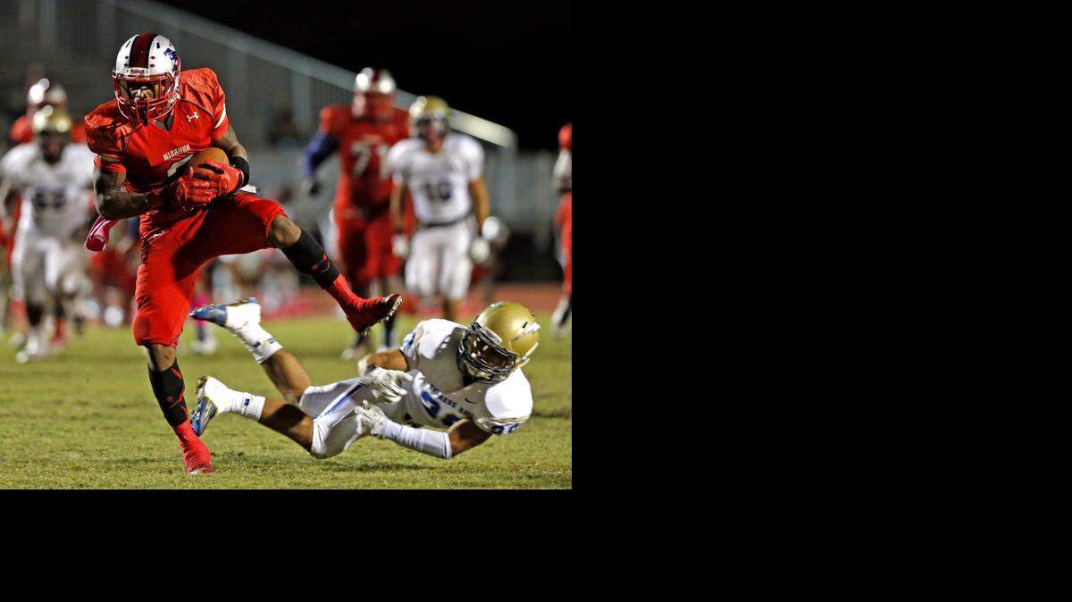 
Miramar receiver Khalil Lewis scores a touchdown in the second quarter after breaking loose from Cypress Bay’s Danny Montoya at Miramar High School, Oct. 24, 2014.
