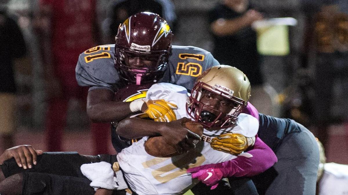 Defensive end Nick Reed (51) and Hallandale defenders gang tackle Coconut Creek’s Malek Young during the second quarter on Friday night. Hallandale rallied from a 22-21 deficit in the third quarter to pull out the victory.