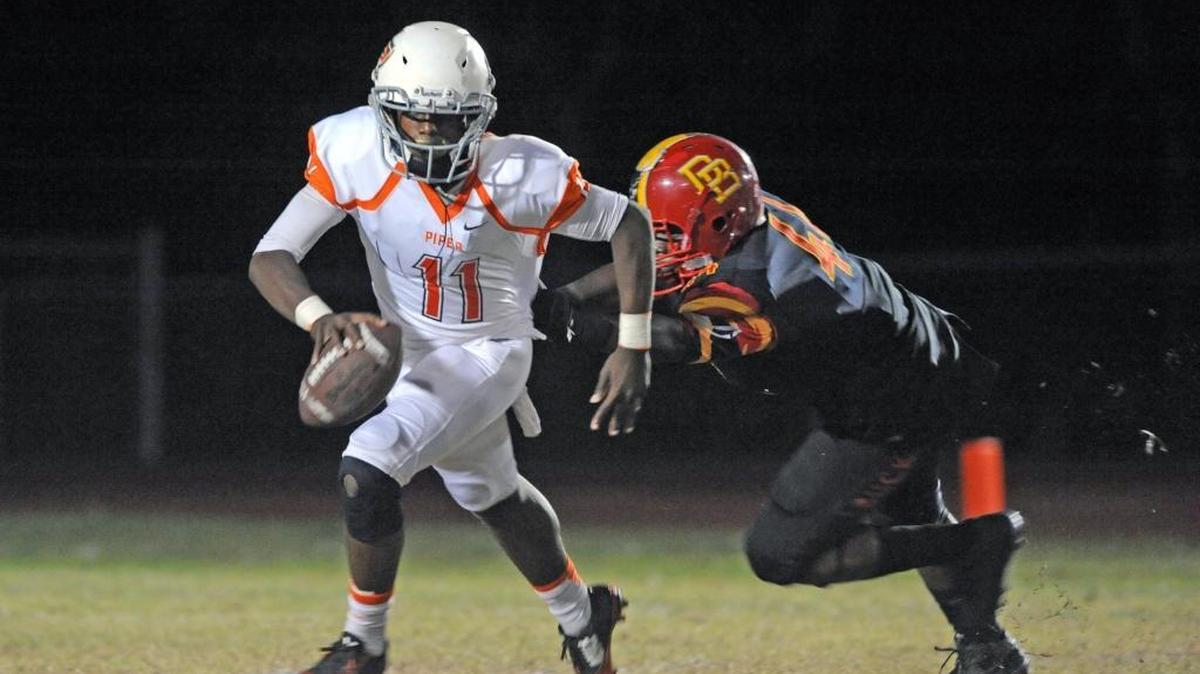 Deerfield Beach’s Jimmie Harper pressures Piper quarterback Rashawn Fraser during the Bucks’ victory that clinched the District 11-8A championship and a berth in the regional quarterfinals.