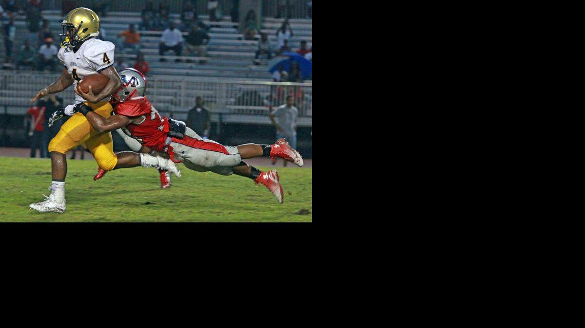 
Along for the ride: St. Thomas Aquinas running back Deltron Sands, left, is tackled by Miramar’s Mark Niles in the second quarter Saturday night.
