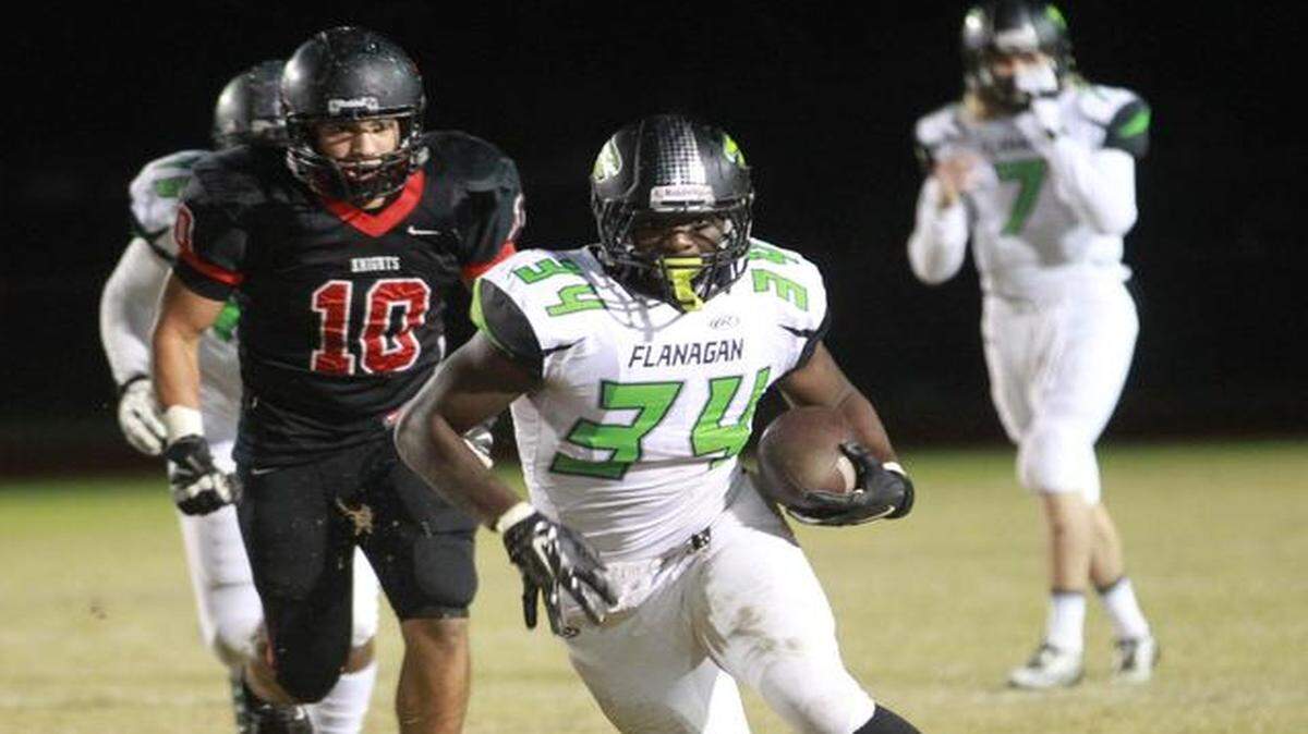 
Flanagan High’s Arkeem Granger (34) runs for yards in their game against Monarch High in a high school football playoff game at Deerfield Beach, Friday, Nov. 21, 2014.
