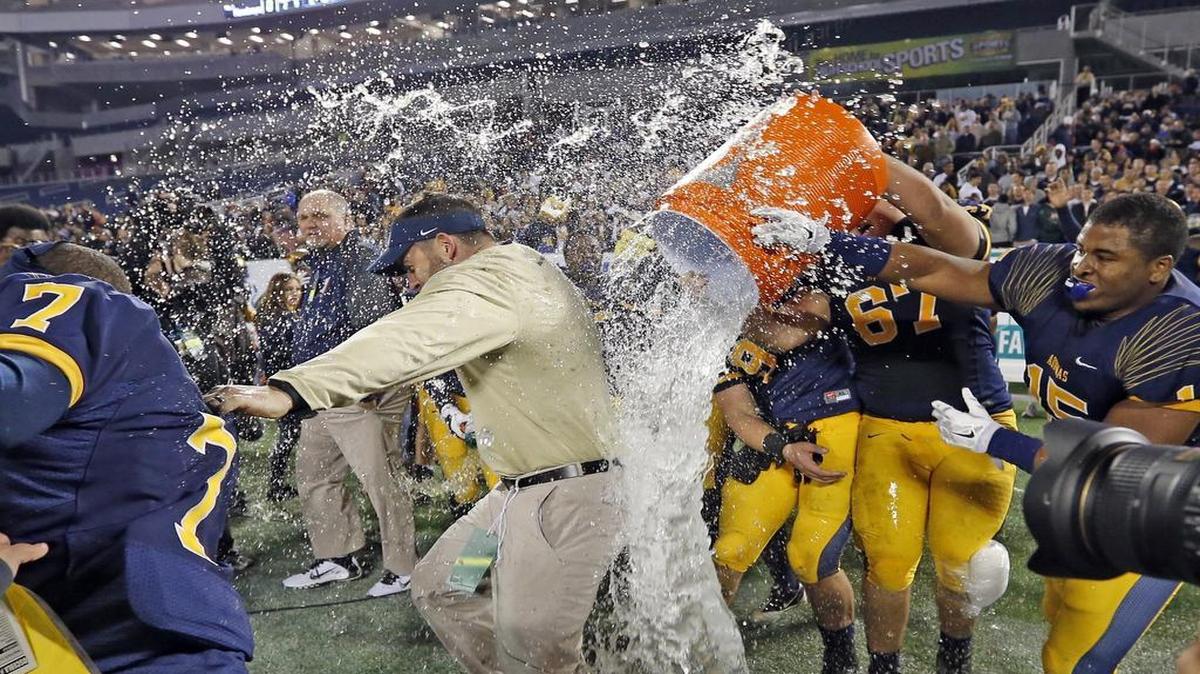
St. Thomas players Samuel Clausman (67) and Brandon Boyce (15) help dump Gatorade on Raiders coach Rocco Casullo after Aquinas defeated Osceola for the Class 7A football state title.
