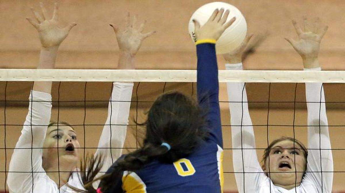
On the attack: St. Thomas Aquinas’ Emma Dixon hits against Pompano Beach High’s Jasmine Sourverein-Reisert (5) and Tara Brannen (3).
