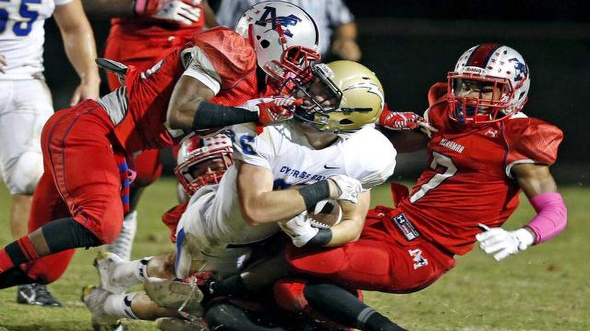 
Trayveon Brownlee pulls on the face mask of Cypress Bay’s Mike Epstein during Miramar’s 34-14 victory on Friday night. 
