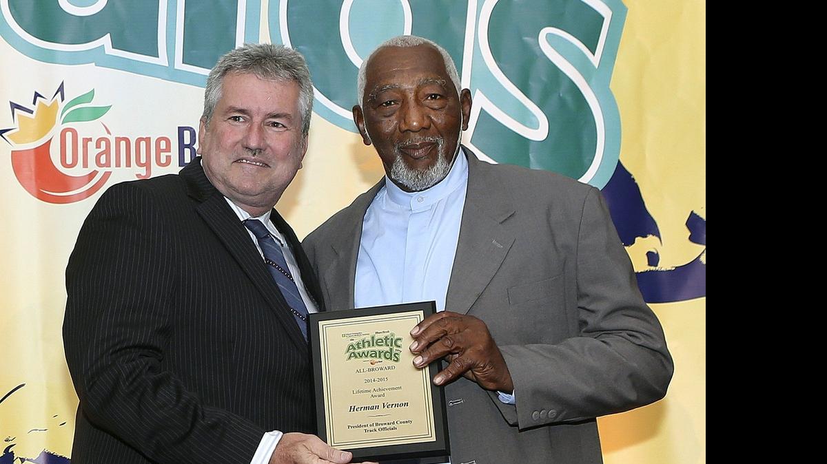 
Herman Vernon, right, accepts the Lifetime Achievement Award from Bill Daley during the Miami Herald’s All-Broward Athletic Awards breakfast Friday, May 22, 2015 at the Signature Grand in Davie.
