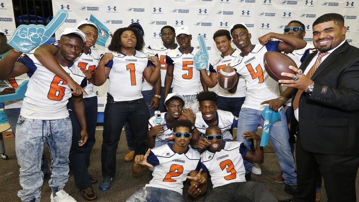 
Stranahan High School football players pose with coach Tally Adams during the Dolphins' high school football media day in August at Nova Southeastern university.
