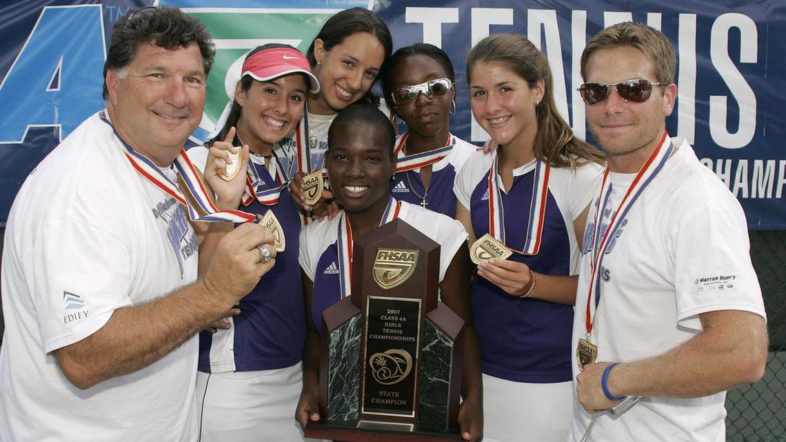 
In this file photo, left to right, Dr. Krop HS tennis coach Coach Michael Kypriss, Taylor Dubins, Maria Roman, top, Deon Miller, holding trophy, Brittany Henry, Brittany Dubins and Coach Damon Hollenback show off their trophy after winning the FHSAA State 4A Tennis Finals in Altamonte Springs, Florida on Thursday, April, 26, 2007.