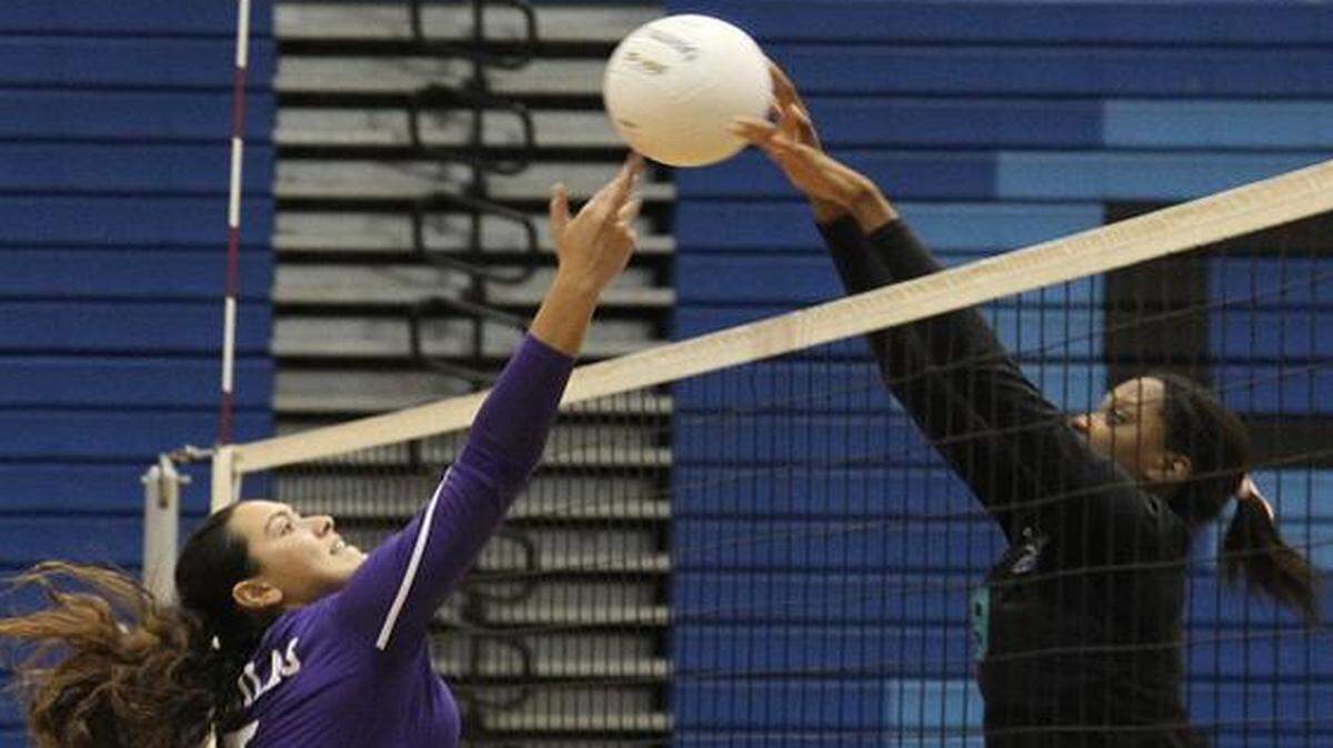 <cutline_leadin>Net result:</cutline_leadin> Coral Reef’s Rishan Duhaney, right, tips the ball back over the net against Southwest defenders in the Region 4-8A quarterfinal.