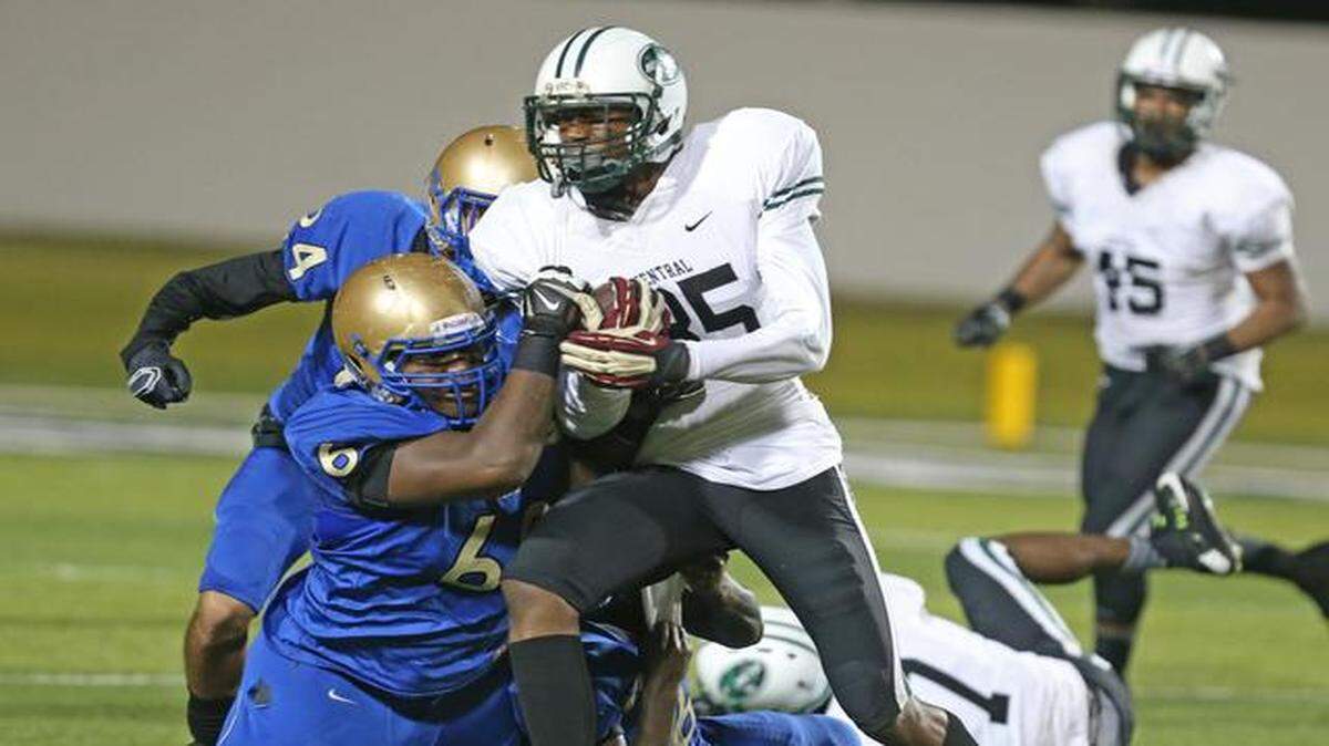 
Miami Central's Jamel Cook returns an interception on Mainland's Rashad Harris (60) during a game at Municipal Stadium in Daytona Beach, Friday, Dec. 5, 2014.
