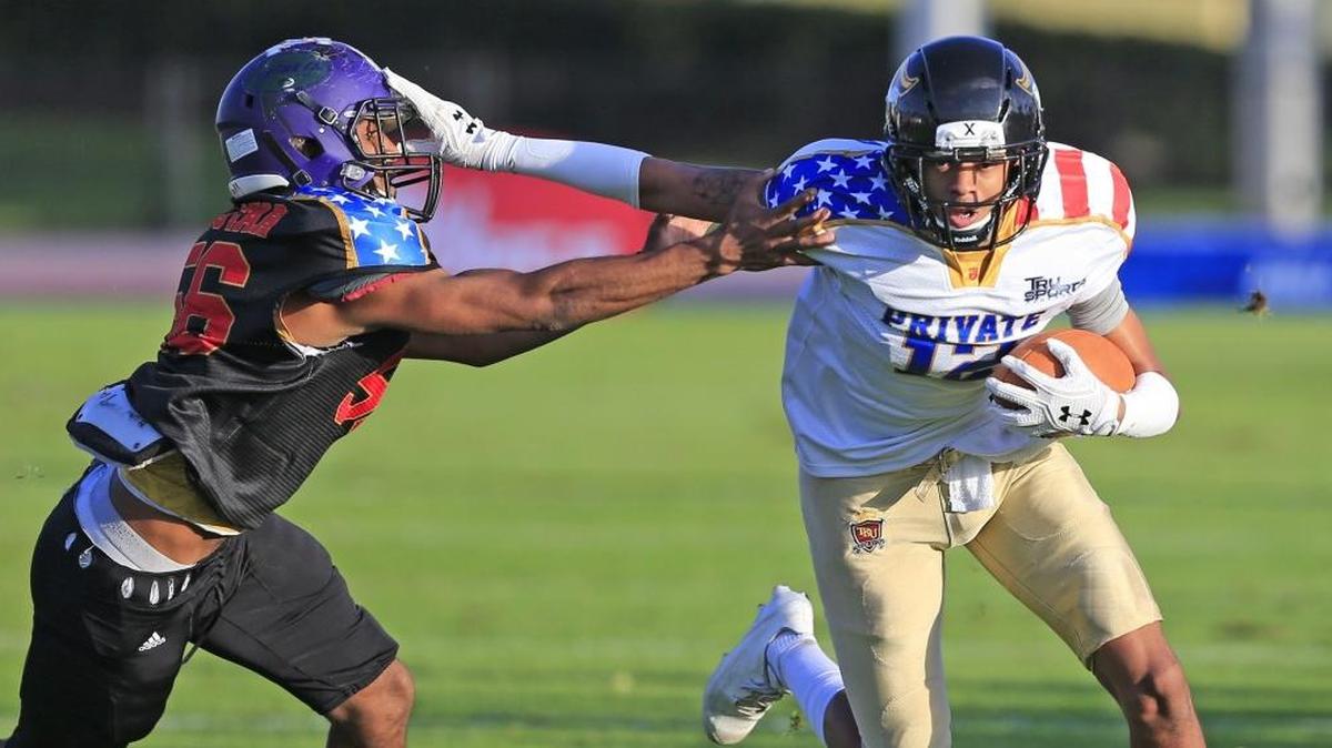 American High's wide receiver Marcus Lodge (12) runs for a first down as Dr. Michael Krop High's linebacker Jarquez Hill (56) defends during Public School vs. Private School South Florida All-Star football game at Ansin Sports Complex in Miramar on Saturday, Jan. 13, 2018.