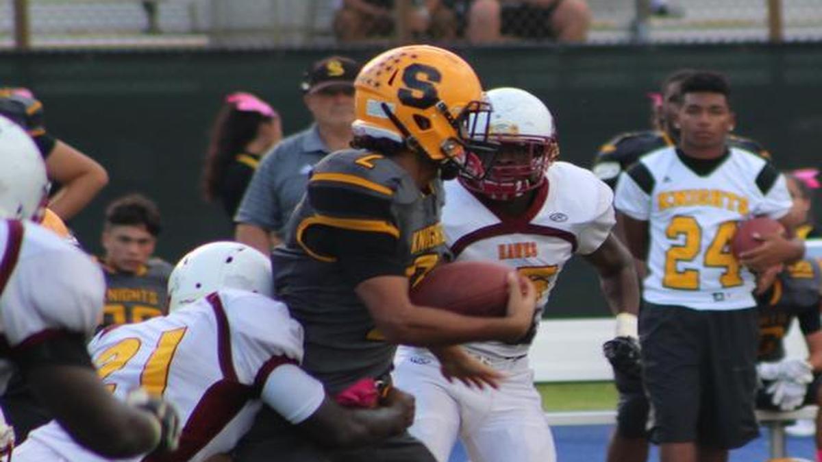 
Sunset’s Tariq Peters tries to break free from the Miami Springs defense during Thursday’s game.
