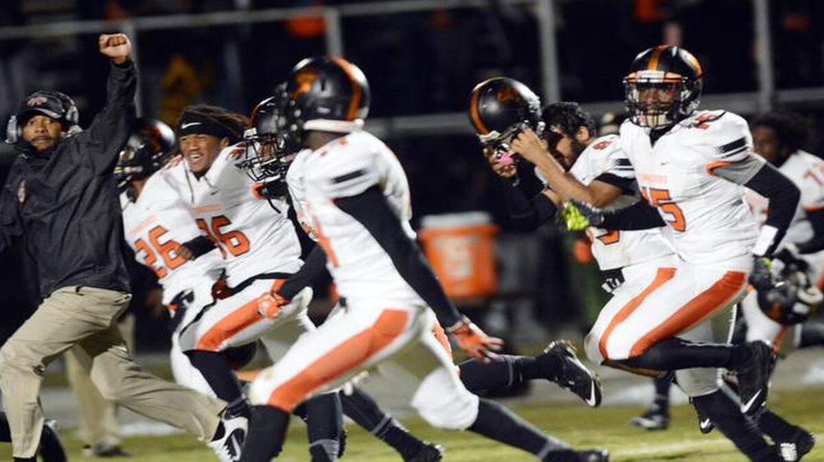 
Booker T. Washington coach Tim Harris, Jr. and his players celebrate their 14-12 victory over Cocoa in the Class 4A state semifinal game.
