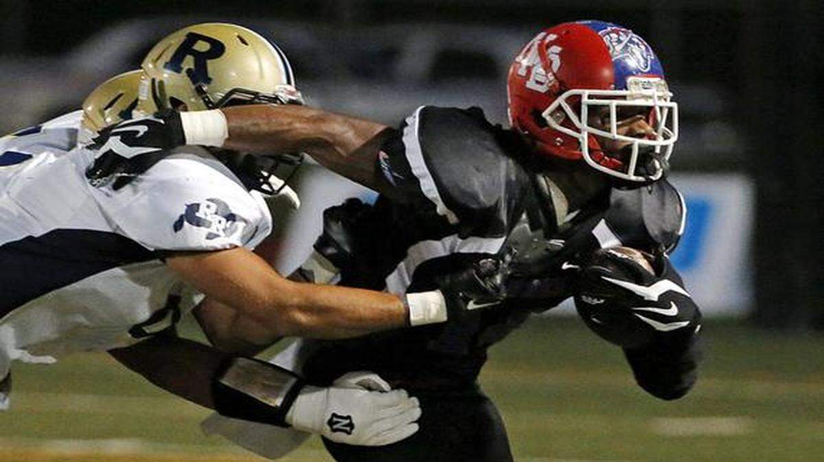 
North Miami Beach's Jordan Atkins (14) evades Ronald W. Reagan's Antonio Vargas (8) in North Miami on Thursday, Oct. 16, 2014.
